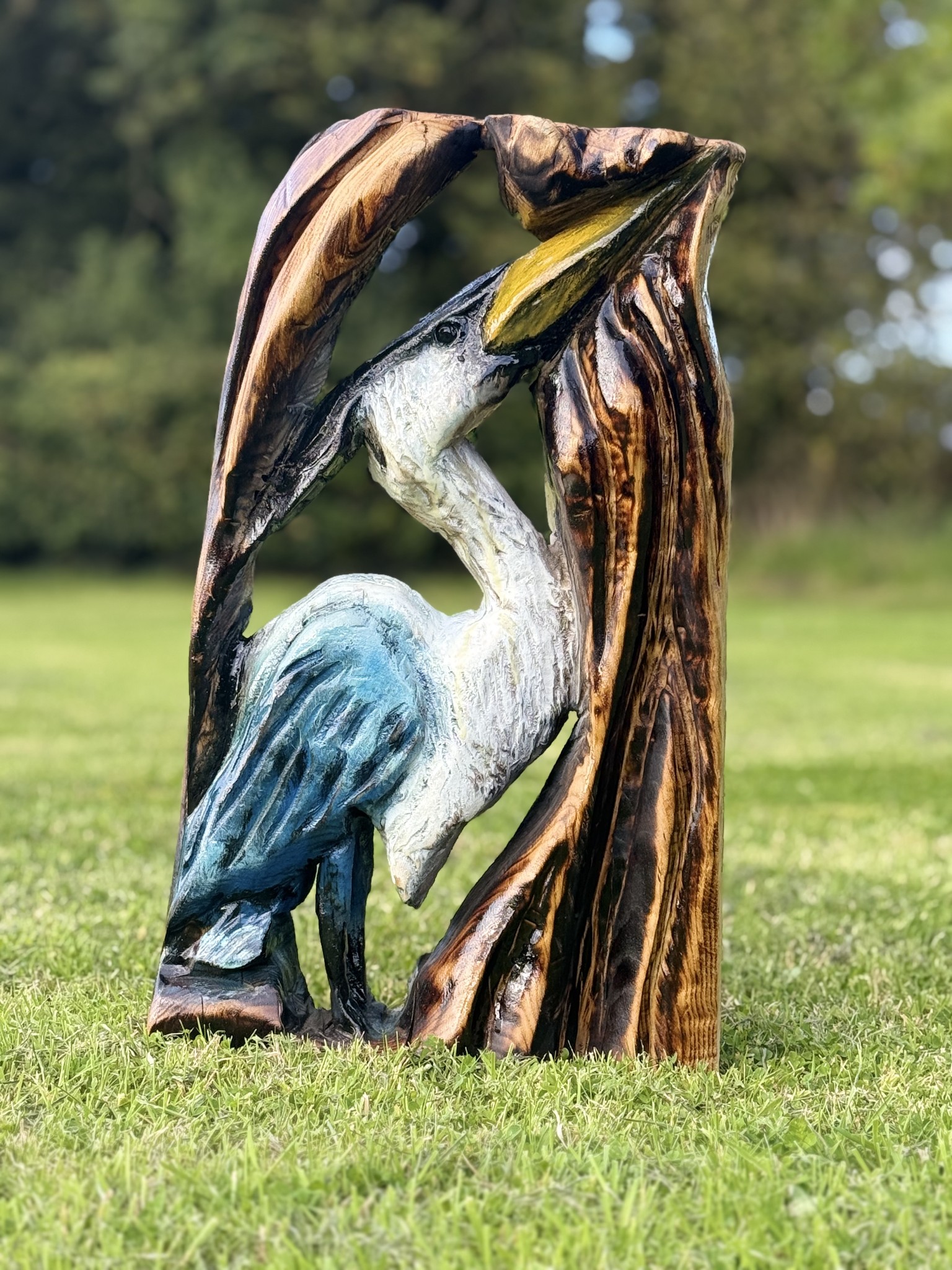 Heron emerging from a carved trunk — chainsaw carving by Woodaknot chainsaw carving & sculpting