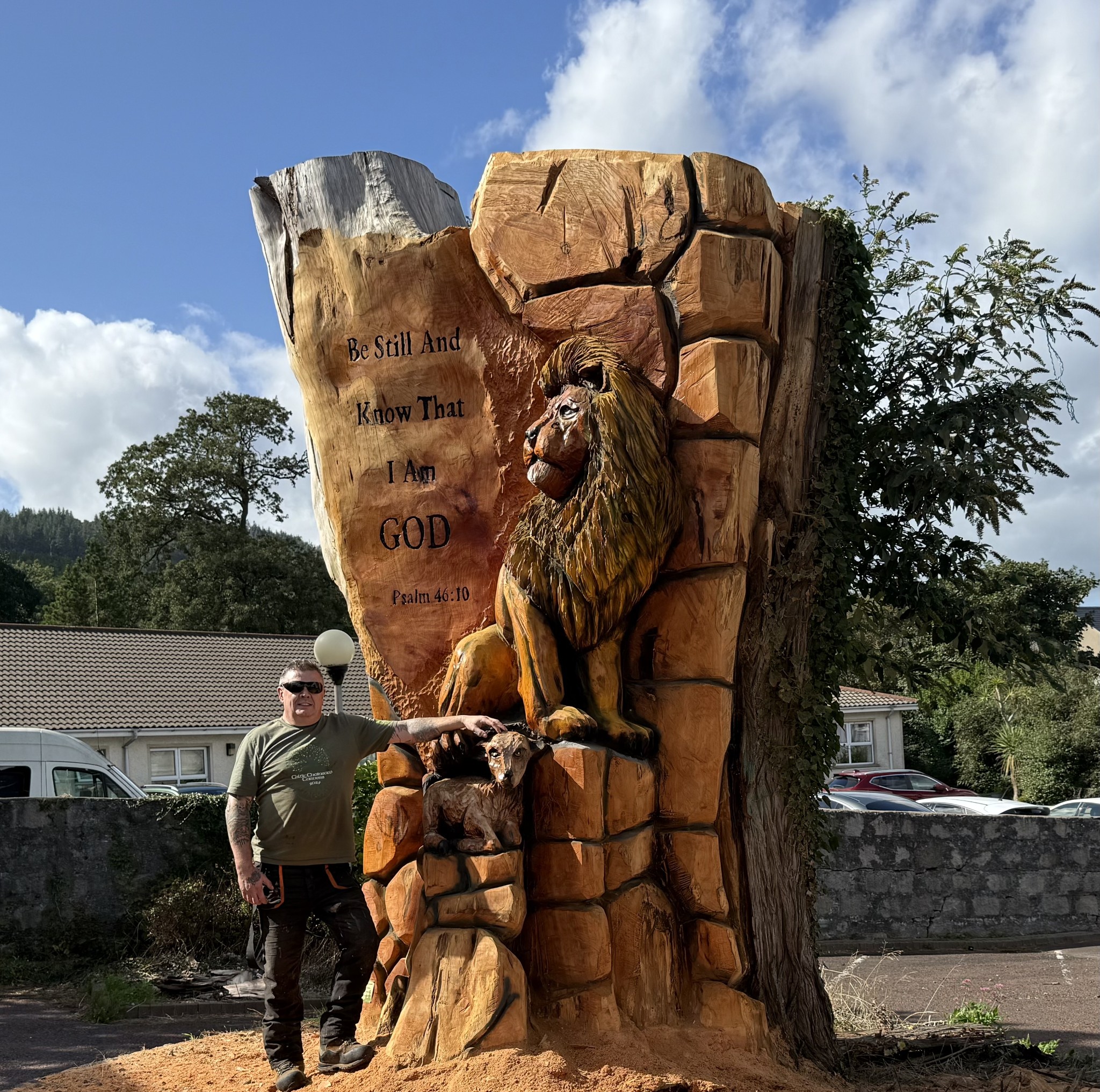 Seated lion on carved rocky plinth — chainsaw carving by Woodaknot chainsaw carving & sculpting